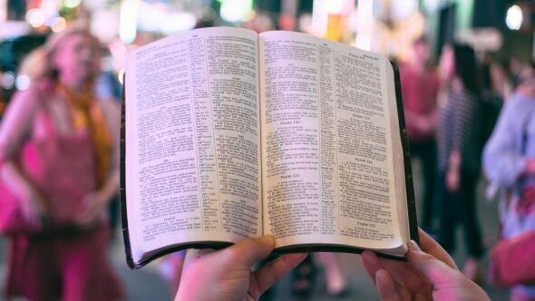 Open Bible in Front of Crowd